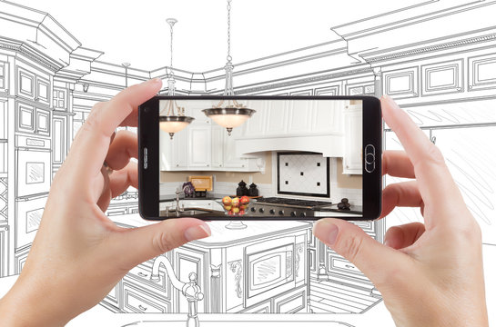 Hands Holding Smart Phone Displaying Photo of Custom Kitchen Drawing Behind.