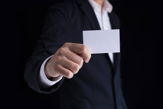 A man in business black suit holding a white blank business card,name card.