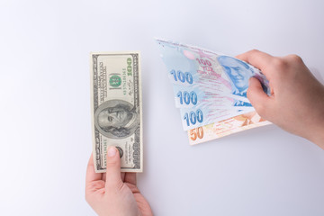 Hands holding American dollar banknotes and Turksh Lira banknote