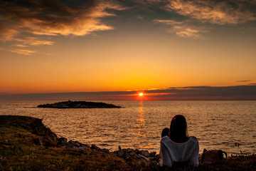 Fototapeta premium Silhouette of girl watching sunset