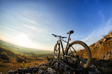 Fototapeta na wymiar Bicycle silhouettes with blue sky on the mound