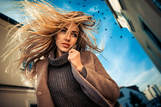 Art outdoor portrait of a beautiful blonde girl in a sunny autumn weather