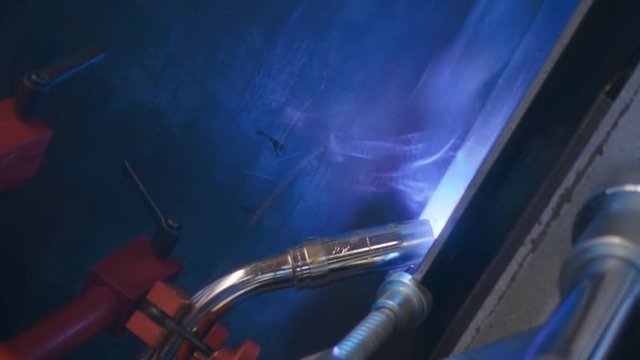 Automatic welding machine going welding of the metal profile. Sparks are flying in different directions. Slow motion, high speed camera, 250fps