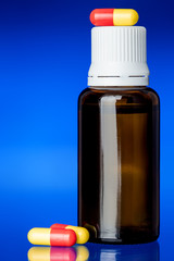 glass bottle cough syrup with a pill.