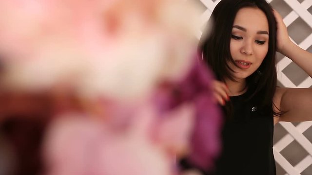 Young beautiful Asian girl posing on the background, the foreground flowers