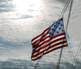 Colonial American fifteen Star flag flying across the rigging of