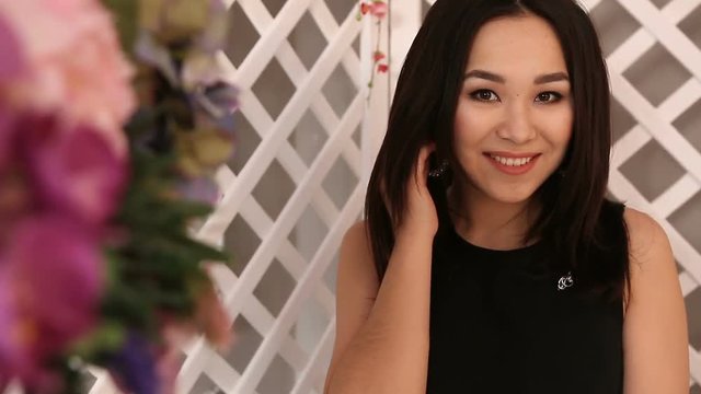 Young beautiful Asian girl posing on the background, the foreground flowers