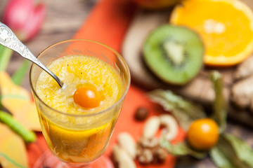 Obst in allerlei Form zum Frühstück, Smoothie zum Löffeln mit Früchten im Hintergrund