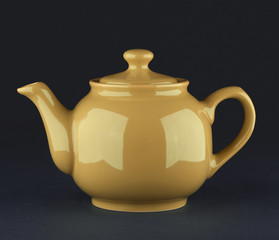 Brown ceramic teapot isolated on black background