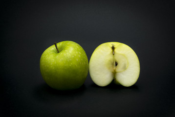 Green apples on black background.