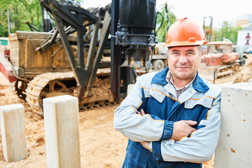 construction worker in front of pile driver machine