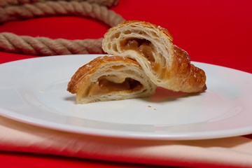 Fresh baked croissant on plate divided on pieces