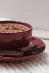 Milk chocolate in a cup on a saucer against a background of a sc