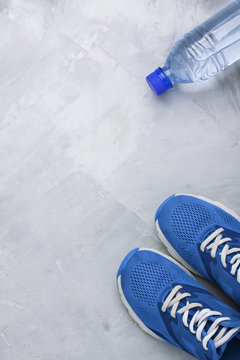 Flatlay sports composition with blue sneakers and bottle of wate