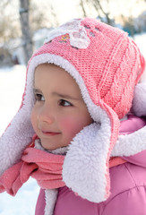 Cute little girl enjoying winter and snow dressed in warm pink c