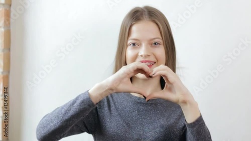 Teen Girl With Braces Making Love Heart Gesture With Hands Stock