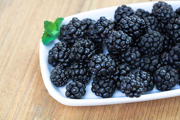 Blackberries on wooden deck no lines on white plate
