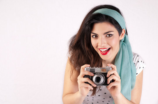 PinUp Girl smiling with a camera in hands