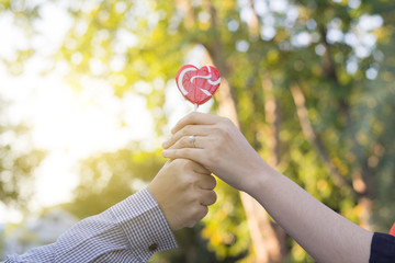 Hands holding lollipop together,valentine day lover concept