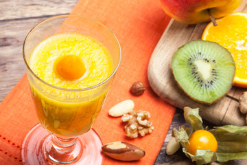 Frühstück mit Obstsaft, Obst und Nüssen auf altem Holztisch
