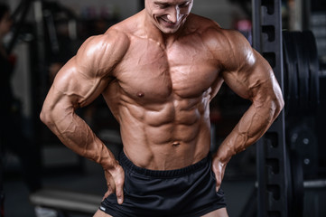 Fototapeta na wymiar Handsome bodybuilder training in the gym sexy man lift dumbbells