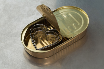 Three metal hearts in a tin