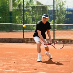 Poster Senior men hitting ball on tennis court © Microgen