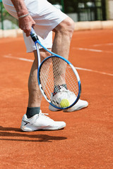 Fototapeta na wymiar Tennis player. Taking ball with racquet from tennis court