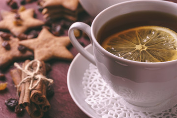 Cup of tea with lemon and handmade ginger cookies and cinnamon at background 