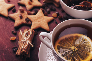 Cup of tea with lemon and handmade ginger cookies and cinnamon at background 
