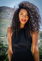 Naklejka premium Black young woman with curly hair and big and beautiful red lips smiling to the camera