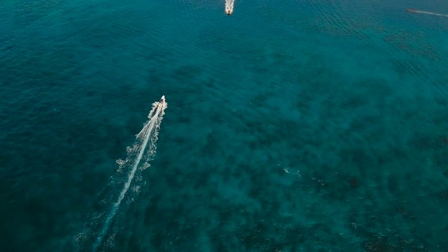 Aerial view of speed boat in sea. Speed boat at sea, view from above. Aerial video of speedboat floating in a turquoise blue sea water. Motorboat crossing ocean. Tropical landscape. Philippines