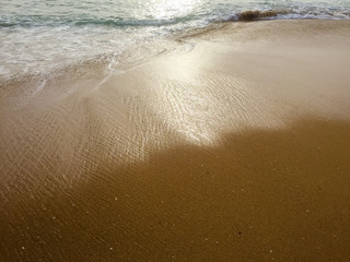 White ocean sea foam and natural sandy surface beach backdrop top view background