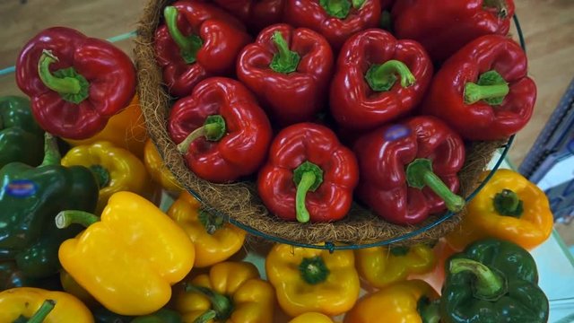 Harvest ripe tasty red, green and yellow sweet peppers on a shop window. Shot in motion
