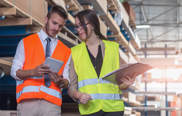 Worker and businessmen with clipboard and tablet at warehouse