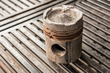 Old piston on the metal table.