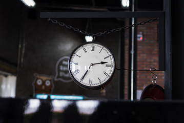 Old clock hanged in coffee shop.