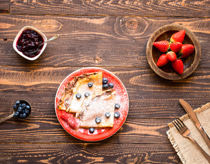 Fototapeta na wymiar Fresh Strawberries Pancakes or Crepes with berries and chocolate