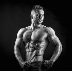 Fototapeta premium Young male fitness model poses on isolated background showing his perfect abs