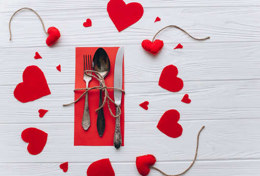Valentine's Day.cutlery and felt heart on a wooden background 