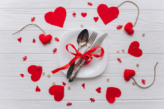 Valentine's Day. plate,cultery, heart felt and decor on wooden background