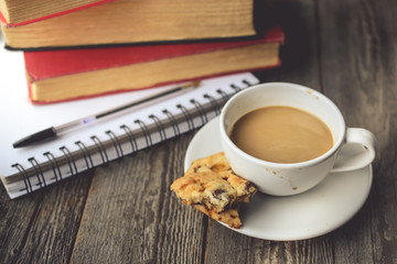 Stack of Book and Cookies with Hot Coffee on Dirty Cup on Wood B