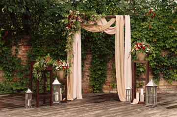 arch for the wedding ceremony, decorated cloth flowers greenery,