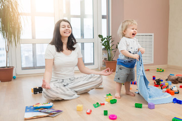 Portrait of young happy yoga mom spending time with her little baby boy