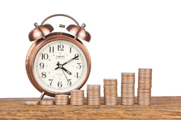 stacks of coins and alarm clock on white a background