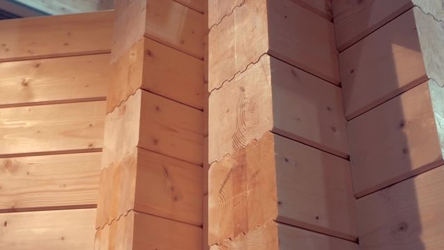 Wooden house from glued timber on the initial stage of construction. Detailed texture of natural wood. Shot in motion