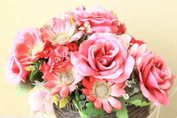 Artificial Flowers with pink roses and Zinnia in basket for decoration wedding party or Valentine's Day as background or print card.