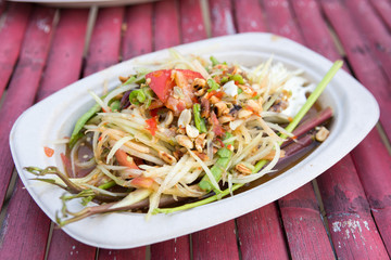 Spicy papaya salad on bamboo table