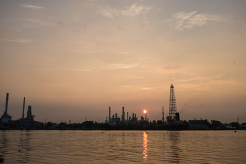Naklejka premium Oil refinery construction plant sunrise with river