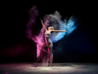 Woman in color dust cloud streches up gracefully